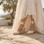 Alpargatas marfil de cuña y cintas al tobillo bajo un vestido de novia con encaje